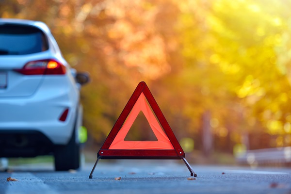 Broken car concept, breakdown triangle on road.