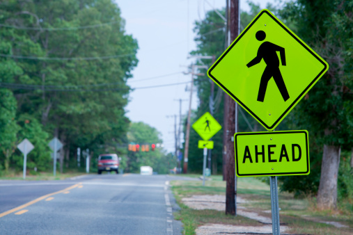 New Crosswalk ahead sign set to the right side of the picture with roadway out of focus to the left. 