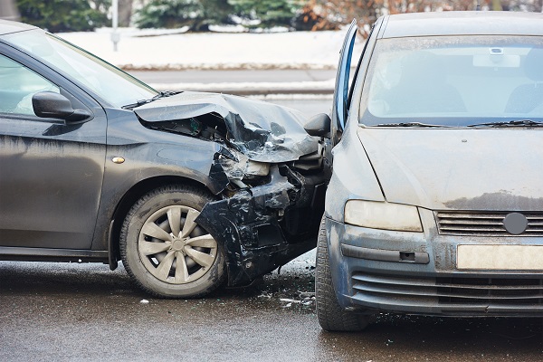 Side-impact crash on a street in Maine between two heavily damaged passenger cars.