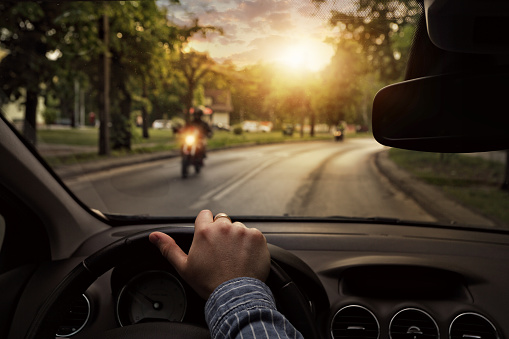 POV driving a car as a motorcyclist approaches