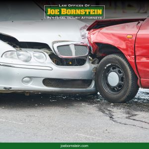 A white luxury car hitting the front of a red car in a Sanford car accident