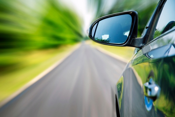 Car speeding on a country road with motion blur background.