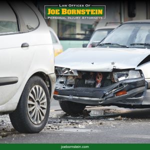A white car with its frontend smashed up in the aftermath of an accident in Windham